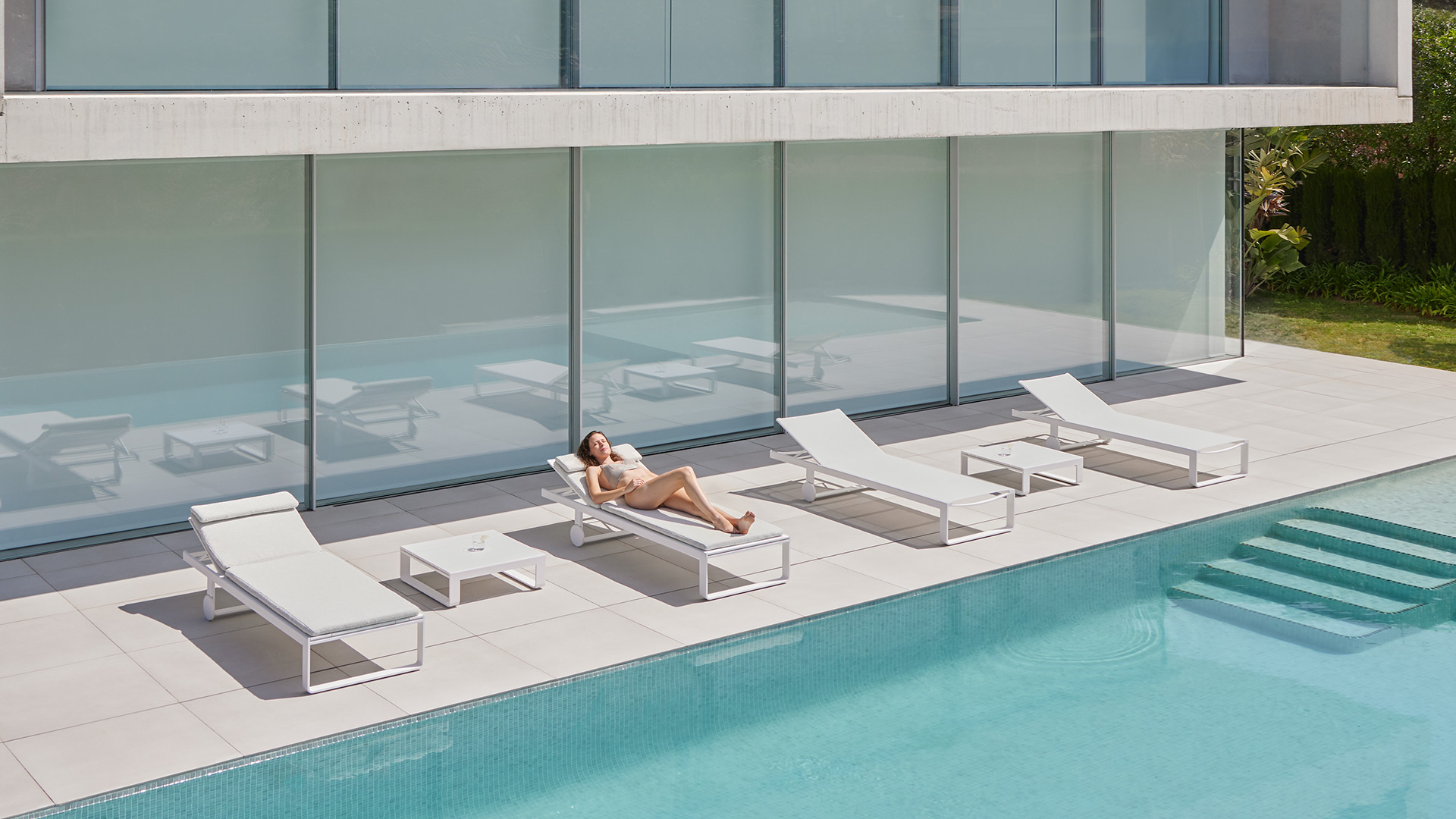 Mobiliario exterior GANDIABLASCO colección Flat tumbonas blancas borde piscina villa Costa del Sol