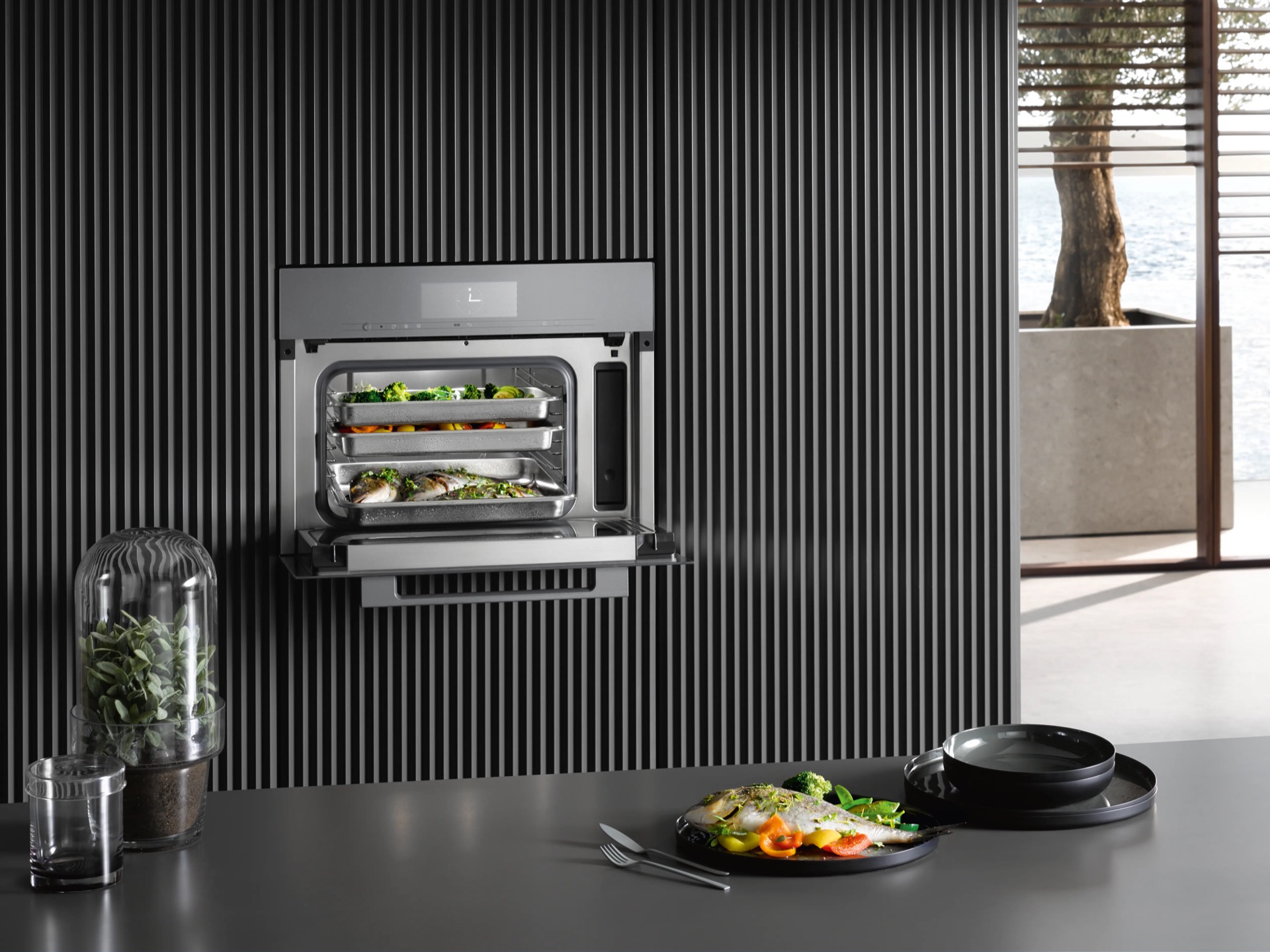 Horno vapor combinado Miele cocinando pescado y verduras pared listones negros integración cocina