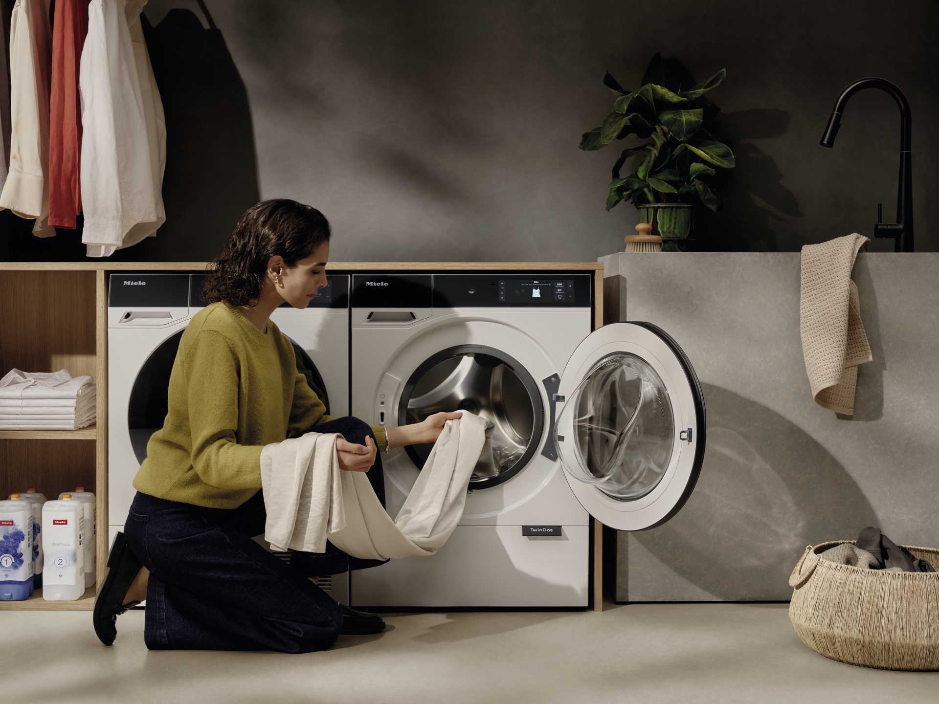 Zona lavandería Miele lavadora TwinDos mujer cargando ropa espacio ordenado interiorismo