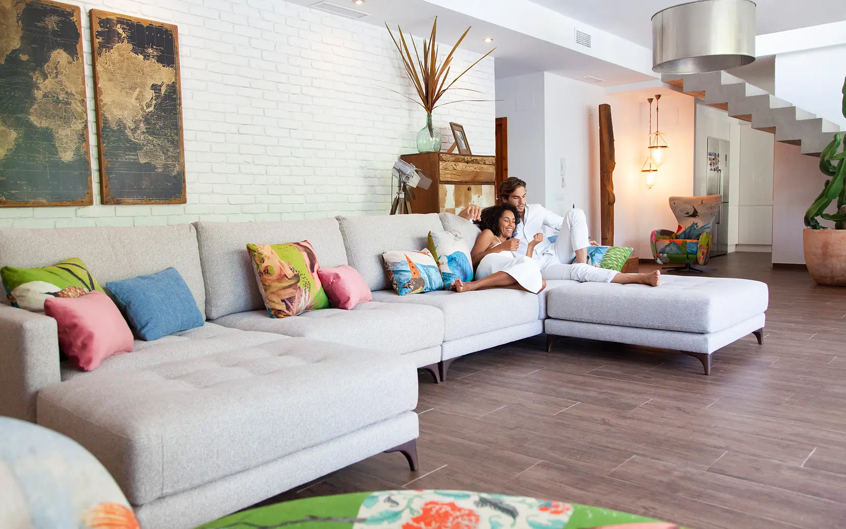 Light grey Fama modular sofa with chaise longue and patterned cushions in the living room of a home in Málaga